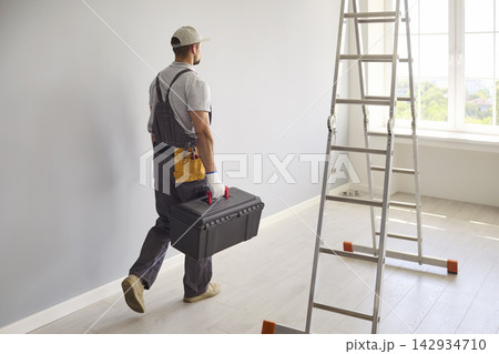Handyman Carrying Toolbox Beside Ladder During Bright Home Renovation Project Handyman Carrying Toolbox Beside Ladder During Bright Home Renovation Project 142934710