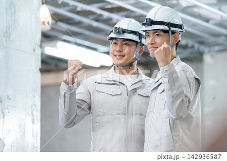 建築現場で打ち合わせをする建設作業員 建築現場で打ち合わせをする建設作業員 142936587