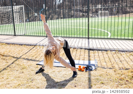 Young woman stretching legs practicing yoga asana outdoors in the park Young woman stretching legs practicing yoga asana outdoors in the park 142938502