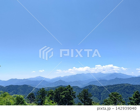 快晴の青空と連なる雄大な山並み 展望台から見渡す山岳風景 快晴の青空と連なる雄大な山並み 展望台から見渡す山岳風景 142939040