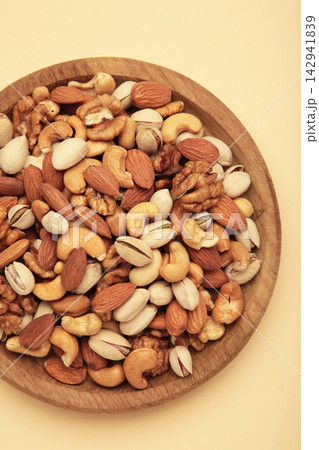 Mix of various nuts in mint bowl on beige background. Pistachios, cashews, walnuts, hazelnuts, peanuts. Space for text Mix of various nuts in mint bowl on beige background. Pistachios, cashews, walnuts, hazelnuts, peanuts. Space for text 142941839