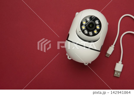 Security camera on red background. Outdoor surveillance camera. Space for text Security camera on red background. Outdoor surveillance camera. Space for text 142941864