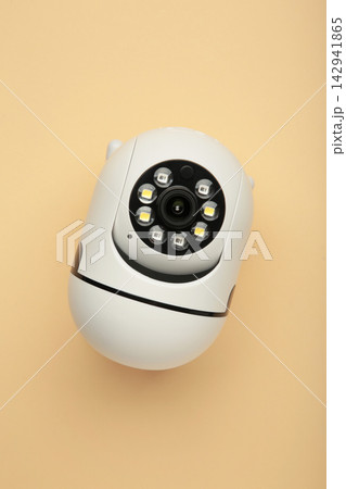 Security camera on beige background. Outdoor surveillance camera. Vertical photo Security camera on beige background. Outdoor surveillance camera. Vertical photo 142941865