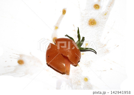 A squashed splattered and crushed broken fresh tomato with seeds 142941958