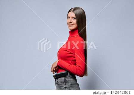 Young woman smiling in half turn profile view on light background 142942061