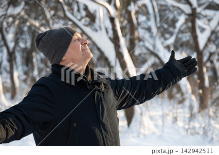 Mature man enjoying fresh air in snowy winter park Mature man enjoying fresh air in snowy winter park 142942511