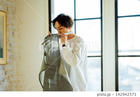 エプロンを首にかけて準備をする男性の姿 エプロンを首にかけて準備をする男性の姿 142942571