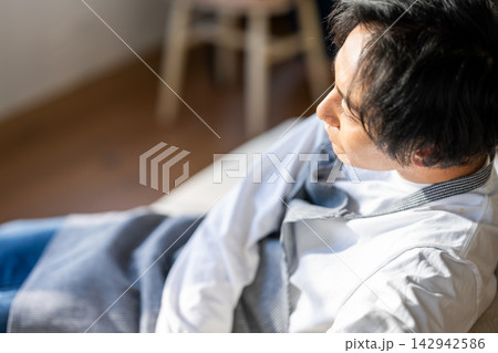 毛布にくるまりリラックスする男性 142942586