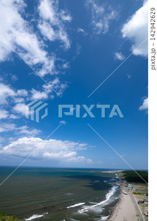 高台から見下ろす雄大な海と砂浜に打ち寄せる白波 高台から見下ろす雄大な海と砂浜に打ち寄せる白波 142942629