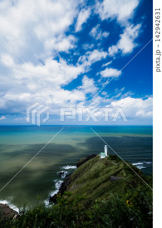 岬の突端に佇む白い灯台とグラデーションが美しい海の絶景 142942631