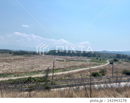 Dry rural countryside landscape with distant blue mountains Dry rural countryside landscape with distant blue mountains 142943276