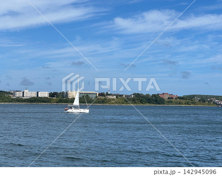 White Sailboat Sailing in Blue Ocean Bay with Seagulls White Sailboat Sailing in Blue Ocean Bay with Seagulls 142945096
