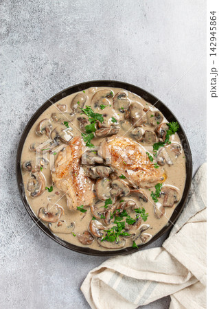 chicken in cream sauce with mushrooms, on a black plate, no people 142945864