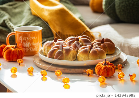 Cozy Autumn Scene Featuring Pumpkin Shaped Buns and Decorative Lights Cozy Autumn Scene Featuring Pumpkin Shaped Buns and Decorative Lights 142945998