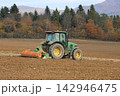 tractor cultivating a field 142946475