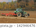 tractor plowing a field 142946476