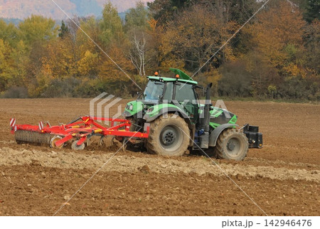 tractor plowing a field 142946476