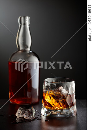 Glass and bottle of whiskey. Glass and bottle of whiskey. 142946611