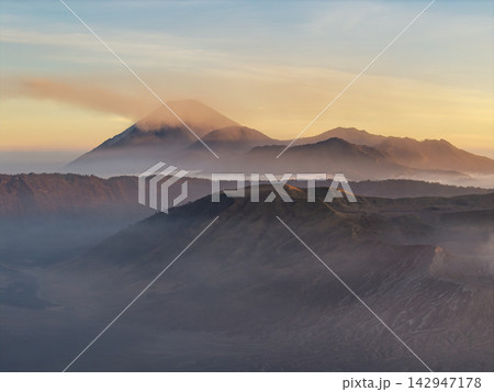 Mount Bromo Volcanic Peaks Emerging Through Mist at Sunset 142947178