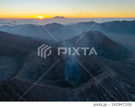 Misty volcano breathes smoke into dawn soft glow 142947208