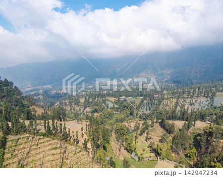 Rolling hills stretch under a bright, cloudy sky Rolling hills stretch under a bright, cloudy sky 142947234