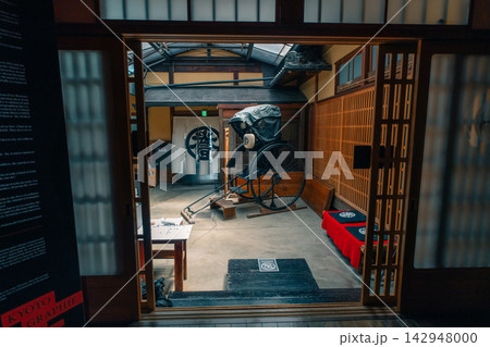 Interior of a traditional Japanese house or museum styled after the samurai era, featuring wooden architecture, tatami flooring, and sliding shoji doors. 142948000
