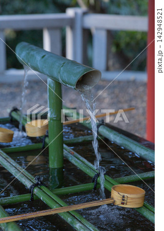 【日本】東京赤坂の日枝神社の手水舎の竹筒から流れ出る水と柄杓 142948521