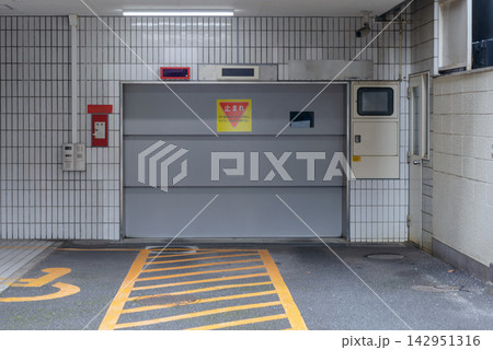 ビルの機械式駐車場と安全標識 立体駐車場の自動ドアと車線表示 ビルの機械式駐車場と安全標識 立体駐車場の自動ドアと車線表示 142951316