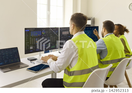 Back view of logistics dispatchers at dashboards, monitoring transport analytics Back view of logistics dispatchers at dashboards, monitoring transport analytics 142952313