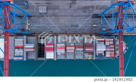 Aerial view of vibrant container ship docked at bustling port with colorful containers, cranes, and tranquil water. global shipping, logistics, and maritime commerce concepts. 142952902