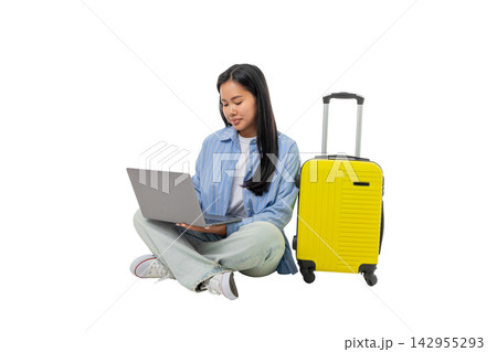 Woman types on laptop next to bright luggage, PNG 142955293