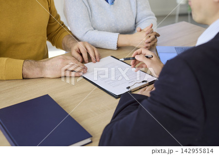 Senior couple signing contract with financial advisor during office consultation Senior couple signing contract with financial advisor during office consultation 142955814