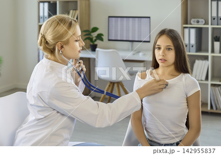 Pediatrician using stethoscope to check girl heartbeat during medical clinic exam 142955837