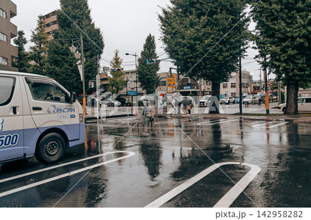 コンビニ駐車場から見た雨の交差点風景 142958282