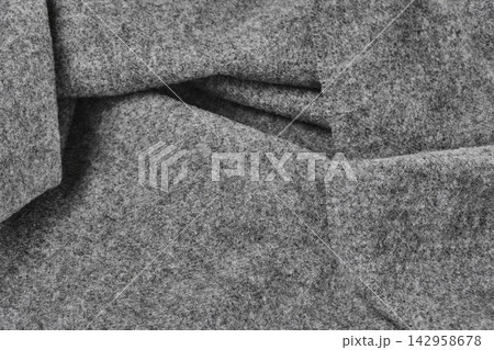 Close-up of soft gray wool felt fabric with deep folds and fuzzy textured surface Close-up of soft gray wool felt fabric with deep folds and fuzzy textured surface 142958678