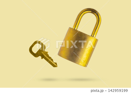Old golden padlock and key fly on yellow background 142959199