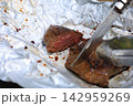 アルミホイルに包んだステーキと野菜のキャンプ焚き火料理 142959269
