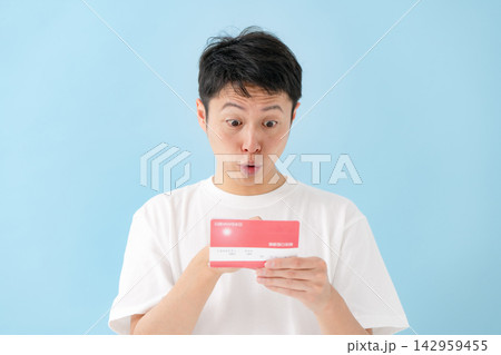 通帳を見て喜ぶ男性 通帳を見て喜ぶ男性 142959455