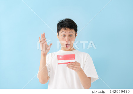 通帳を見て喜ぶ男性 通帳を見て喜ぶ男性 142959459
