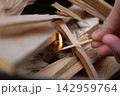 焚き付けに火をつける手のキャンプ着火シーンクローズアップ 142959764