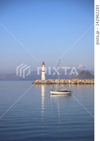 Seascape at sunshine. Lighthouse and sailings on the coast. Seaside town of Turgutreis and spectacular sunshine 142962283