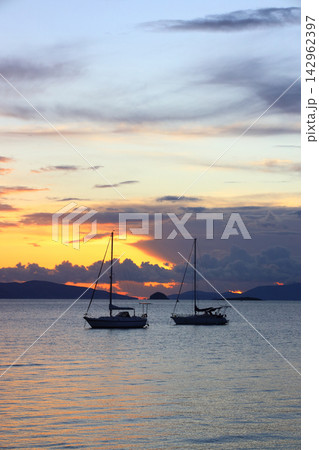 Alone sailboats at sunset. Atmospheric seascape with reflection 142962397