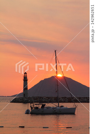 Seascape at sunshine. Lighthouse and sailings on the coast. Seaside town of Turgutreis Seascape at sunshine. Lighthouse and sailings on the coast. Seaside town of Turgutreis 142962651