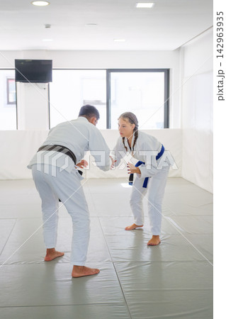 Instructor and student sparring in a jiu jitsu dojo Instructor and student sparring in a jiu jitsu dojo 142963935