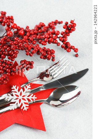 Christmas table setting with cutlery in red star shaped cutlery holder on light gray background Christmas table setting with cutlery in red star shaped cutlery holder on light gray background 142964221