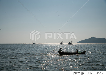 Fishermen - a man and a woman, mother and son, unravel the polluted fishing net and smile, prepare the net for the next fishing Fishermen - a man and a woman, mother and son, unravel the polluted fishing net and smile, prepare the net for the next fishing 142964547