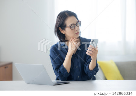 スマホを見るミドル女性　 142966334