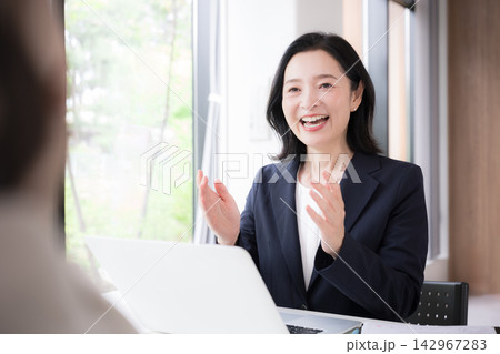 笑顔で説明する50代の日本人女性ビジネス、住宅のローン金利見直しファイナンシャルプランナーイメージ 142967283