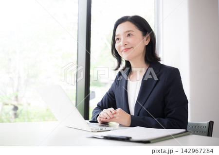 笑顔で説明する50代の日本人女性ビジネス、住宅のローン金利見直しファイナンシャルプランナーイメージ 142967284
