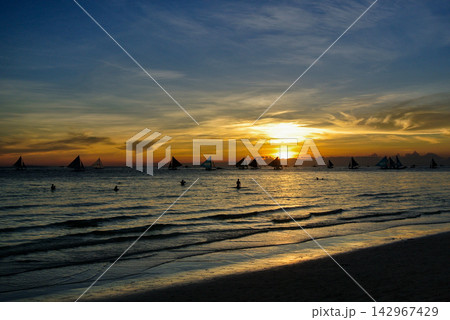 Tropical Sunset Seascape with Silhouettes of Sailing Boats and a Child 142967429